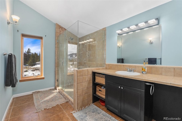 full bath with a shower stall, baseboards, vaulted ceiling, tile patterned floors, and vanity