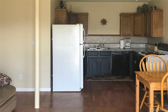 kitchen featuring tasteful backsplash, freestanding refrigerator, black dishwasher, and a sink