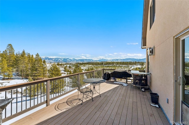 snow covered deck with a mountain view