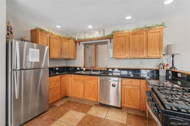 kitchen with a sink, dark countertops, appliances with stainless steel finishes, and recessed lighting