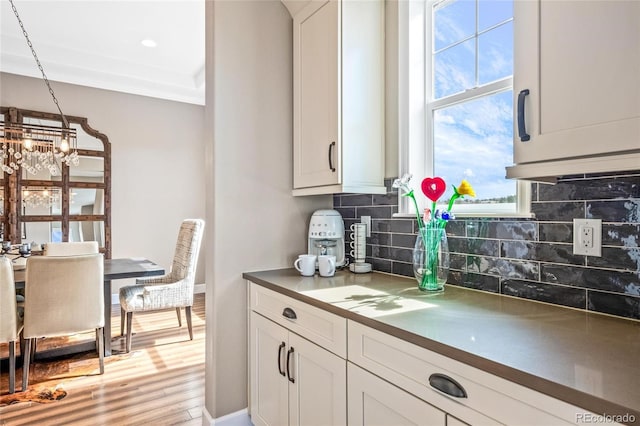 9563 Red Primrose St, Franktown, CO 80116 - kitchen with backsplash, healthy amount of natural light, wood finished floors, and white cabinets