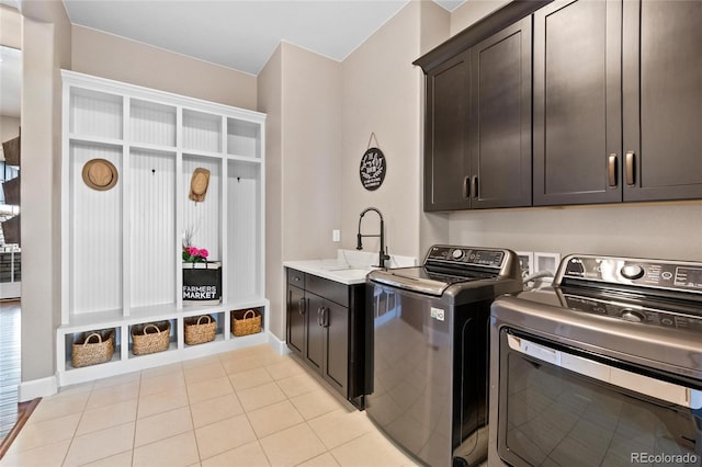 9563 Red Primrose St, Franktown, CO 80116 - clothes washing area with cabinet space, washing machine and dryer, light tile patterned floors, and baseboards