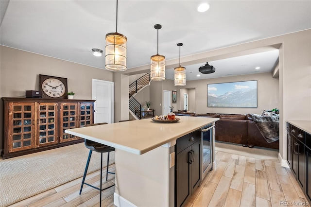 9563 Red Primrose St, Franktown, CO 80116 - kitchen with beverage cooler, light wood finished floors, light countertops, a kitchen breakfast bar, and recessed lighting