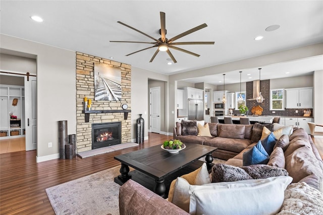 9563 Red Primrose St, Franktown, CO 80116 - living area with a ceiling fan, wood finished floors, a stone fireplace, baseboards, and recessed lighting