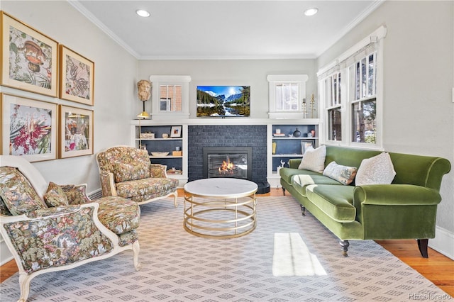 living room featuring hardwood / wood-style flooring, ornamental molding, and a fireplace