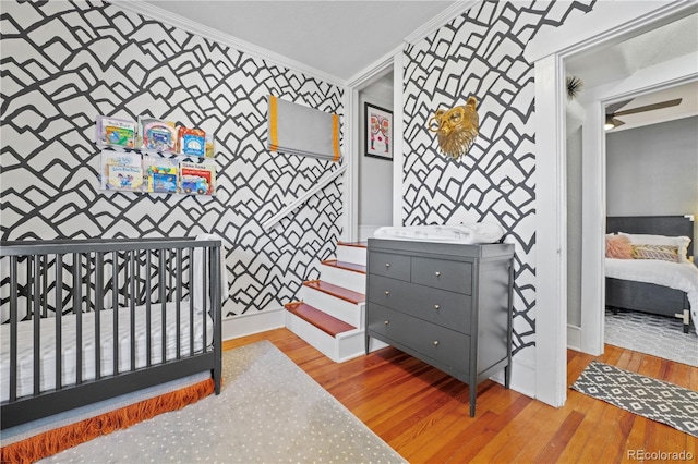 bedroom with ornamental molding and light wood-type flooring