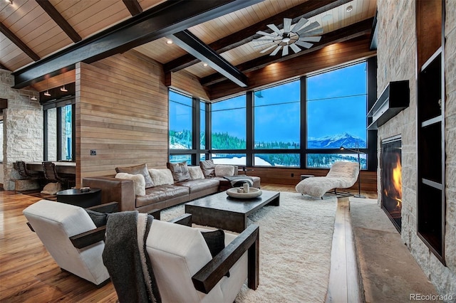 65 Aerie Dr, Silverthorne, CO 80498 - living room featuring a wooden ceiling with exposed beams, a fireplace, wood finished floors, a ceiling fan, and wooden walls