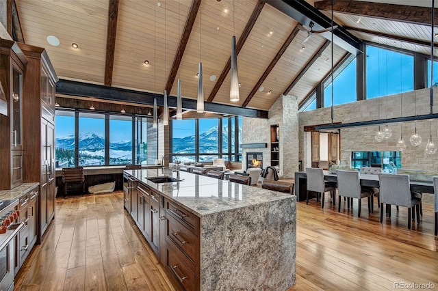 65 Aerie Dr, Silverthorne, CO 80498 - kitchen featuring high vaulted ceiling, a mountain view, a wood ceiling with exposed beams, light wood finished floors, and light stone counters