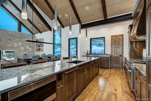 65 Aerie Dr, Silverthorne, CO 80498 - kitchen featuring custom range hood, high vaulted ceiling, double oven range, a wood ceiling with exposed beams, and light wood-style floors
