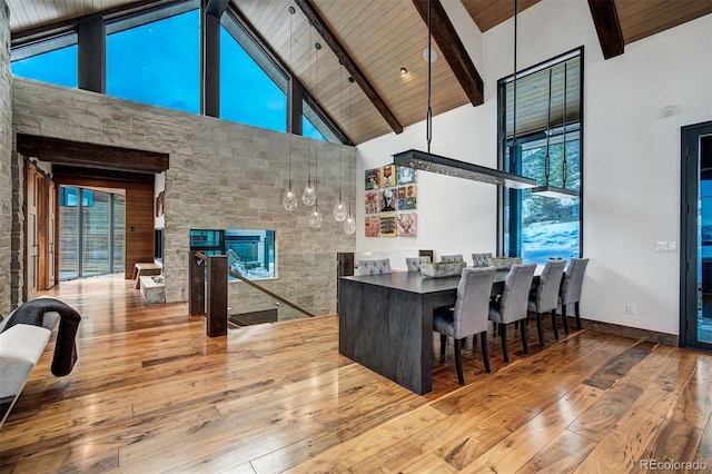 65 Aerie Dr, Silverthorne, CO 80498 - dining space featuring high vaulted ceiling, wood-type flooring, healthy amount of natural light, a multi sided fireplace, and a wood ceiling with exposed beams