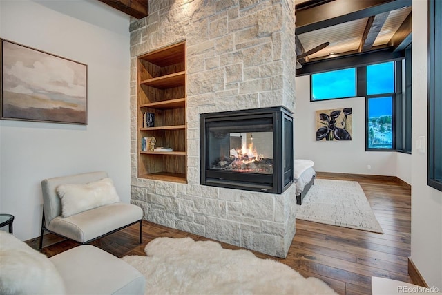 65 Aerie Dr, Silverthorne, CO 80498 - living area featuring wood-type flooring, a fireplace, built in features, and a wooden ceiling with exposed beams