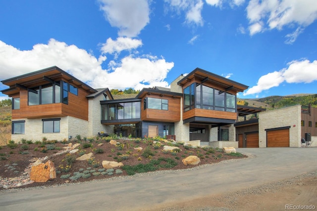 65 Aerie Dr, Silverthorne, CO 80498 - contemporary home with a sunroom, stone siding, a garage, and driveway