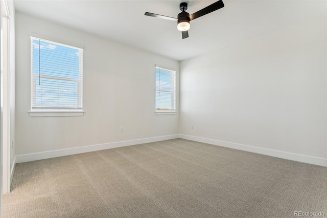 empty room featuring light carpet, ceiling fan, and baseboards