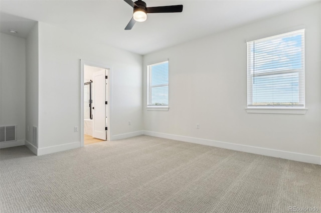 unfurnished room with baseboards, visible vents, and light colored carpet