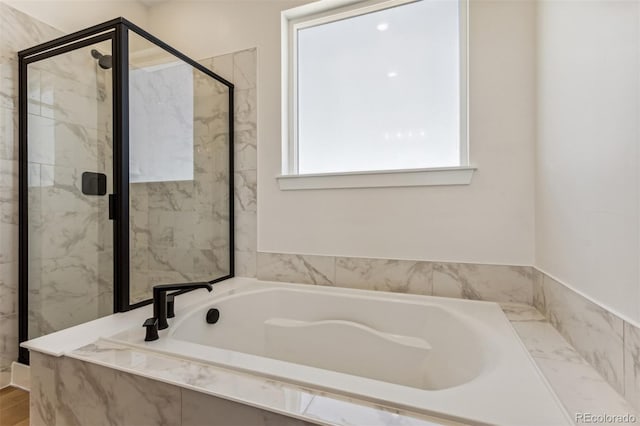 bathroom featuring a garden tub and a shower stall