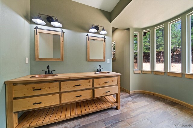 776 Hilltop Rd, Palmer Lake, CO 80133 - bathroom featuring baseboards, double vanity, a sink, and wood finished floors