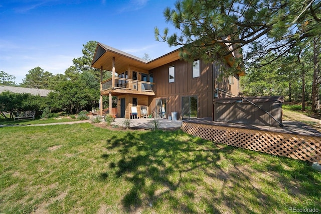 776 Hilltop Rd, Palmer Lake, CO 80133 - back of property featuring a hot tub, a patio, board and batten siding, a balcony, and a lawn