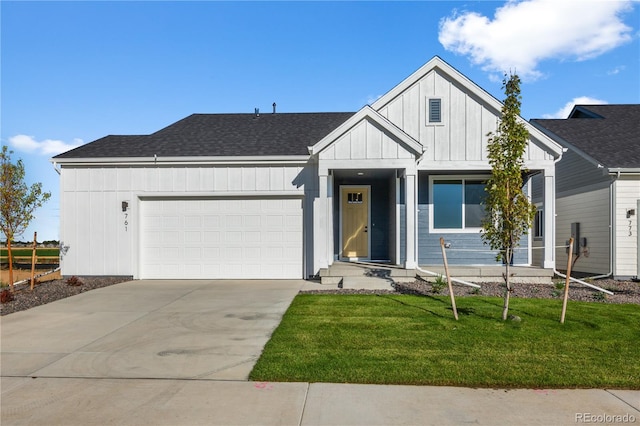 view of front facade featuring board and batten siding, an attached garage, driveway, a front yard, and roof with shingles