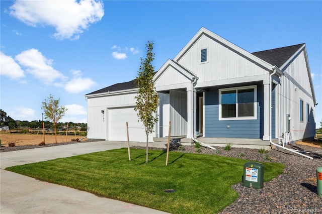 modern farmhouse featuring a garage, a front yard, driveway, and board and batten siding