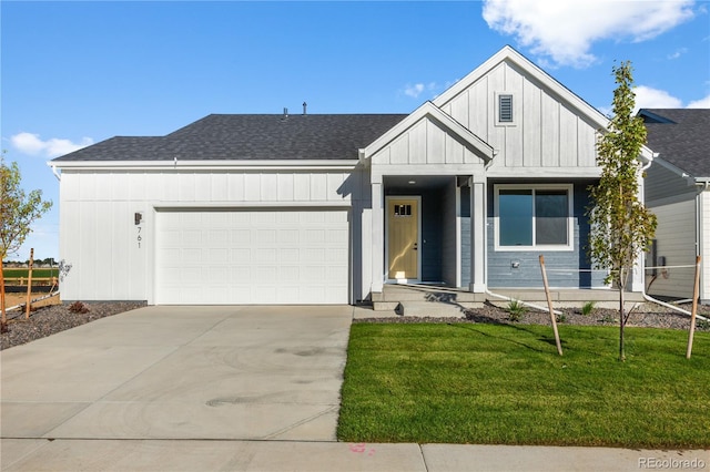 view of front of house with board and batten siding, a garage, concrete driveway, a front yard, and roof with shingles