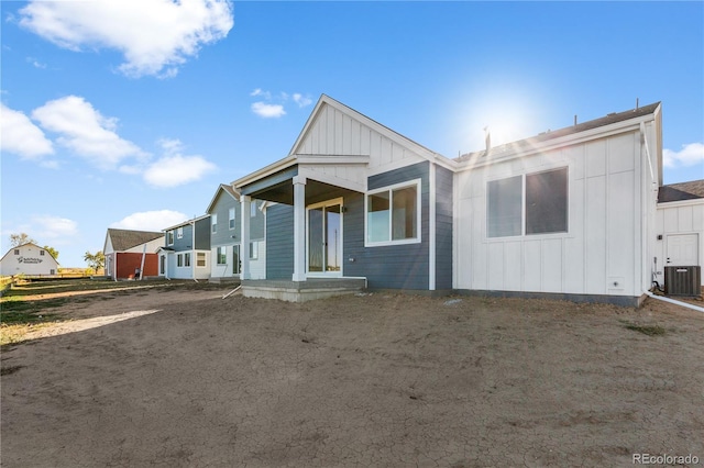 back of house featuring board and batten siding and central air condition unit