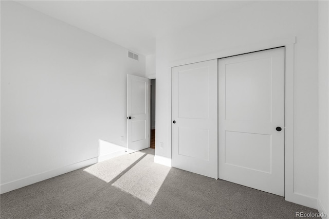 unfurnished bedroom featuring carpet floors, a closet, and baseboards