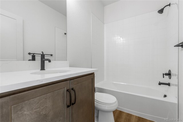 full bath with toilet, vanity, wood finished floors, and shower / tub combination