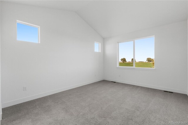 unfurnished room featuring lofted ceiling, carpet, and baseboards