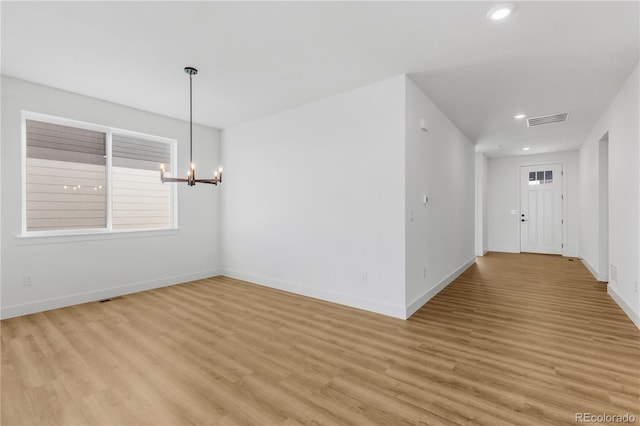 spare room with light wood finished floors, a chandelier, baseboards, and recessed lighting
