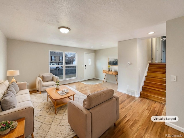 living room featuring a textured ceiling and light hardwood / wood-style flooring