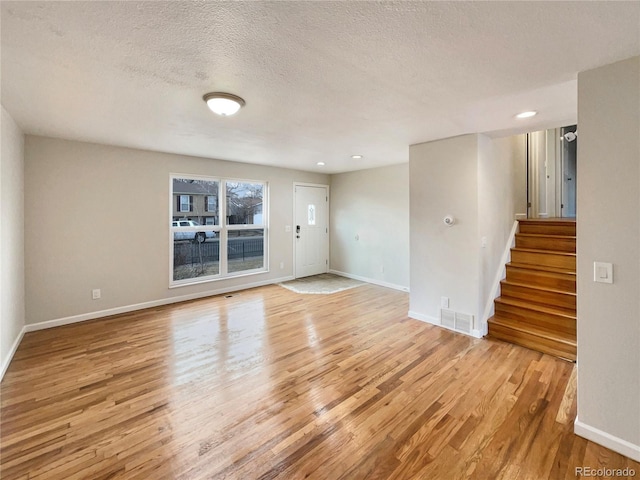 interior space with a textured ceiling and light hardwood / wood-style flooring