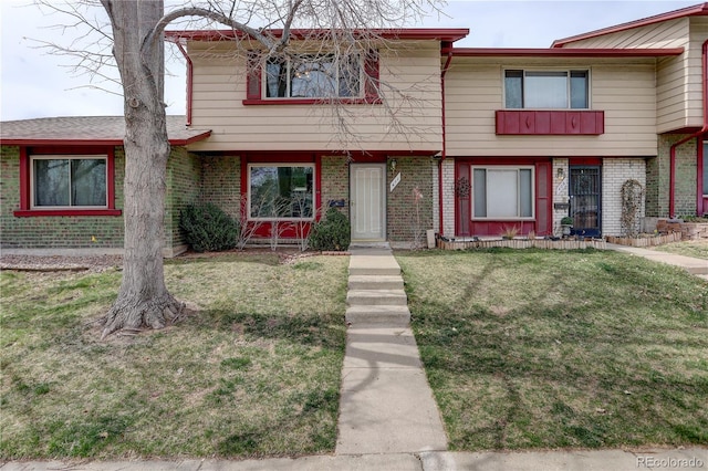 view of front facade featuring a front yard and brick siding