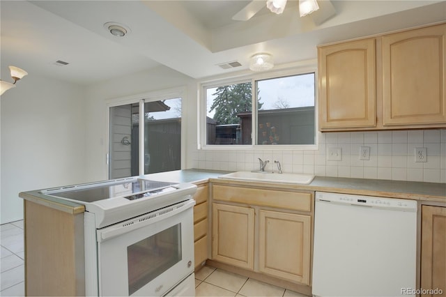 kitchen featuring white appliances, visible vents, a sink, and light brown cabinets