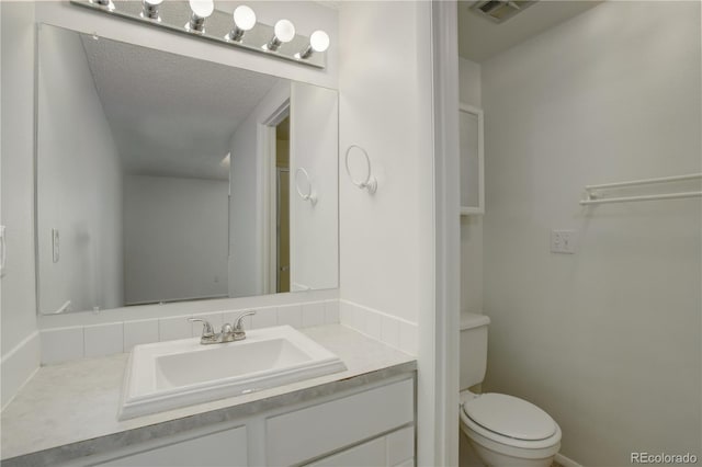 bathroom featuring visible vents, toilet, and vanity