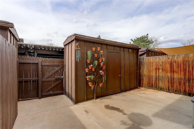 view of shed with a fenced backyard and a gate