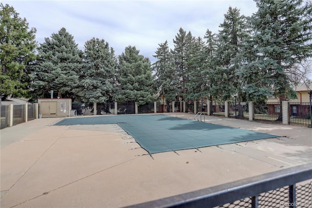 pool with a patio and fence
