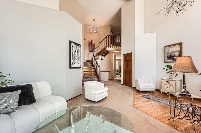 carpeted living room featuring a chandelier, stairs, high vaulted ceiling, and baseboards