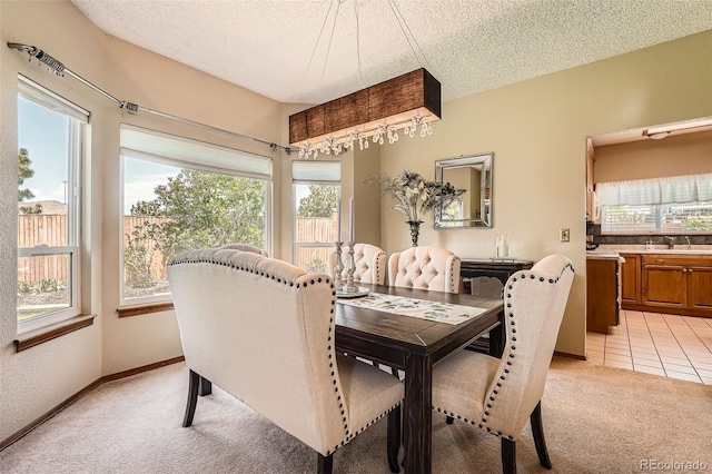 dining space with light colored carpet and a textured ceiling