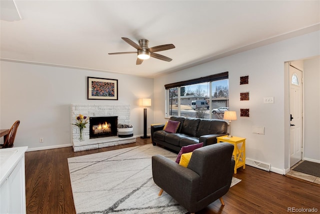 living area with visible vents, a ceiling fan, dark wood-style flooring, and baseboards