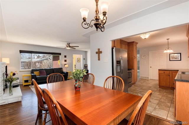 dining room featuring wood finished floors and ceiling fan with notable chandelier