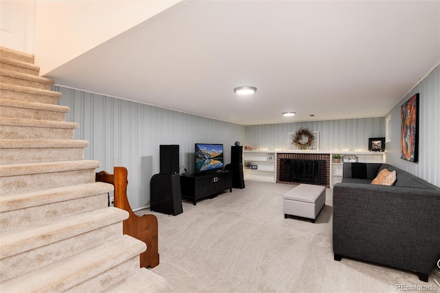 living area with light carpet, a fireplace, and stairs