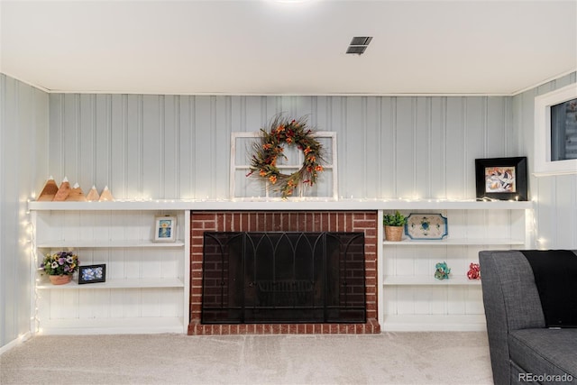 living room featuring carpet flooring, a fireplace, and visible vents