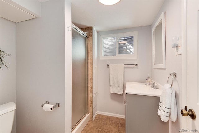 bathroom featuring vanity, baseboards, a stall shower, tile patterned floors, and toilet