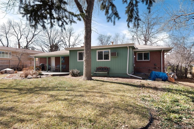 back of house featuring a patio, a wall unit AC, fence, a yard, and brick siding