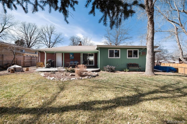 back of house with a yard, fence, and a chimney