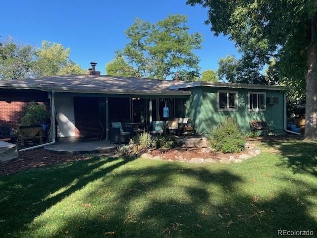 rear view of house featuring a patio area and a yard