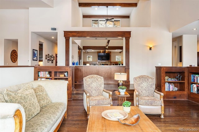 living room featuring dark hardwood / wood-style floors, beam ceiling, and a high ceiling