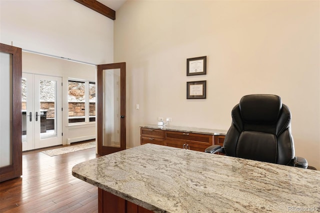 office featuring french doors, a towering ceiling, wood-type flooring, and beamed ceiling