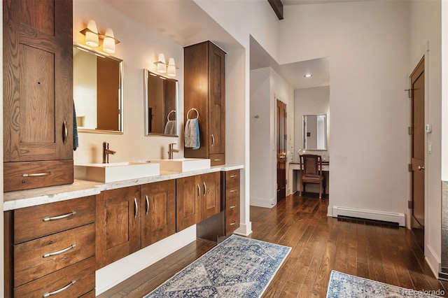 bathroom with vanity, hardwood / wood-style floors, and baseboard heating