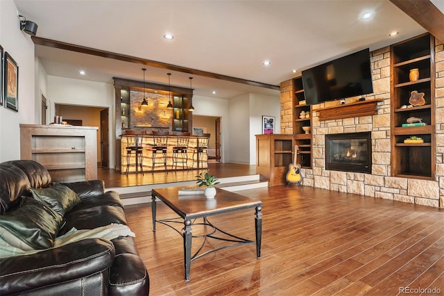 living room featuring hardwood / wood-style flooring, a fireplace, and built in features